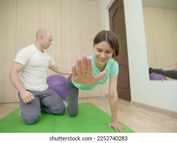 Physical therapist assisting young woman relieve back pain. Advanced Sport Physiotherapy Specialist Working on Specific Muscle Groups or Joints. Sportswoman undergoing Rehabilitation. - Powered by Shutterstock