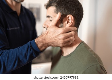A physical therapist carefully performing a neck adjustment on a patient, using osteopathic manual techniques to alleviate cervical discomfort. - Powered by Shutterstock
