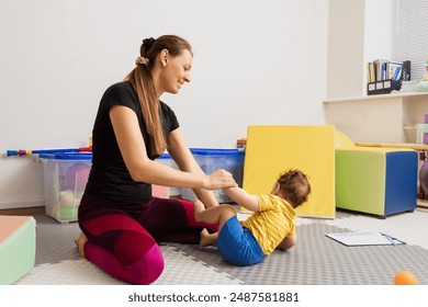 Physical therapist examining boy patient for presence of reflexes and assessed health using Hammersmith test. HINE - Powered by Shutterstock