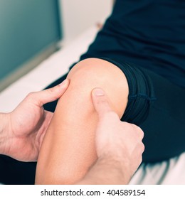 Physical therapist examining patient's knee
