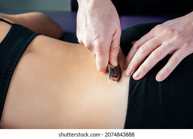 Physical therapist fixing sacroiliac joint or SI joint pain with IASTM tool, Instrument assisted soft tissue mobilization technique for soft tissue treatment