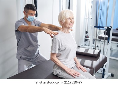 Physical Therapist Giving Massage To Shoulders Of Happy Lady