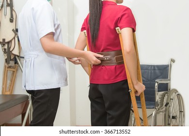 Physical Therapist Helping Patient To Walk Using Crutches  In Hospital, Physical Rehabilitation Therapy