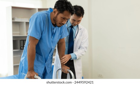 Physical therapist helping a patient while stretching his legs on a bed in a clinic or hospital. Young man attends a physiotherapy course on muscle weakness pain. and heel pain with elastic - Powered by Shutterstock