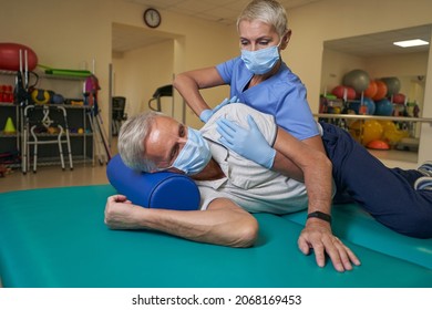 Physical Therapist Helping Stroke Patient In Rehab Center