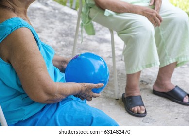 Physical Therapist Helps A Senior Woman Exercise Using A Ball.