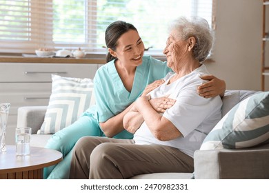 Physical therapist hugging senior woman on sofa at home - Powered by Shutterstock