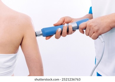 A physical therapist performs shock wave therapy with magnetic field assistance for targeted rehabilitation. Perfect for showcasing modern pain relief and advanced recovery techniques. - Powered by Shutterstock