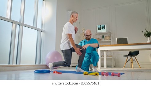 A Physical Therapist Safely Trains a Patient Using Medical Exercise Equipment at the Rehabilitation Center. Elderly Health Support Concept - Powered by Shutterstock