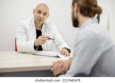 Physical Therapist Talking To Male Patient During Medical Appoitment At The Office