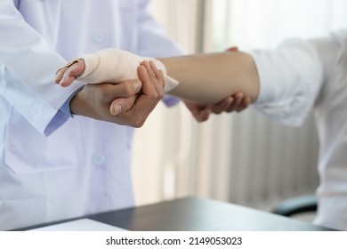 Physical therapy. First aid and wrist injury treatment. Doctor wrapped around the wrist for first aid with a particular emphasis on the application of bandages on the patient's hands. - Powered by Shutterstock