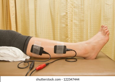 Physical therapy , woman with eletrical stimulator for increase muscle strength and release pain