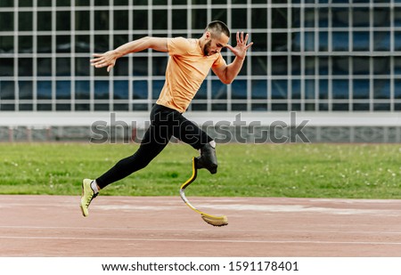 physically disabled athlete running with prosthetic legs
