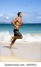 Physically Fit Man Running On Maui, Hawaii Beach.