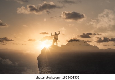 Physically and mentally strong man on a mountain top flexing his muscle. Achievement and success concept. - Shutterstock ID 1933401335