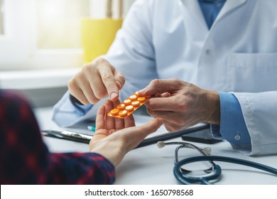 Physician Consulting Female Patient About Pills. Doctor Prescribing Medicine Sitting At The Desk In The Clinic Office