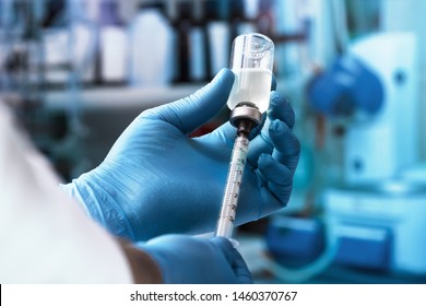 physician filling syringe with dose of vaccine / Doctor hand holding syringe and vaccine - Shutterstock ID 1460370767