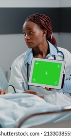 Physician Holding Digital Tablet With Horizontal Green Screen, Showing Technology To Patient. Medic And Person Looking At Isolated Mockup Template And Background On Chroma Key Display