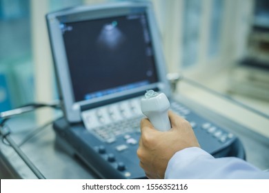 Physician holding ultrasound probe of echocardiogram machine for examination.
