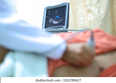 Physician making echocardiography for male patient heart, focus screen of echocardiography machine