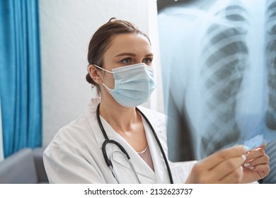 Physician In Mask Looking At Chest Radiograph