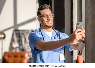 Physician With A Radiant Smile Taking Photos Of Himself