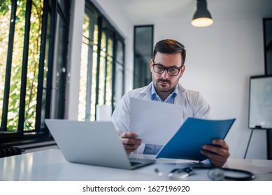 Physician reviewing medical chart, portrait. - Powered by Shutterstock