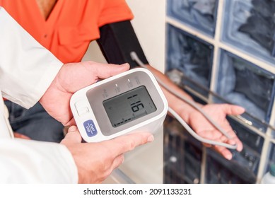 Physician Taking Blood Pressure And Pulse On The Arm Of A Patient At The Clinic