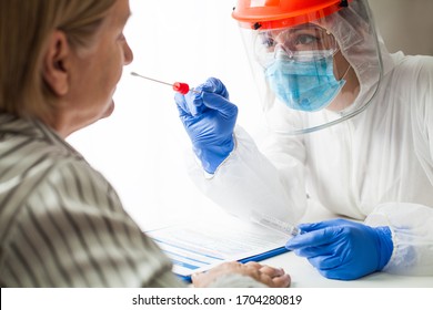 Physician wearing personal protective equipment performing a Coronavirus COVID-19 PCR test, patient nasal NP and oral OP swab sample specimen collection process, viral rt-PCR DNA diagnostic procedure
