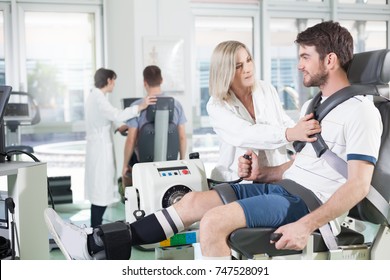 Physicians With Patients In A Gym For Physical Rehabilitation Dynamometer In The Foreground And In The Background Cycle Ergometer/ Gym Physiatric Rehabilitation