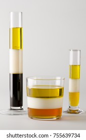 Physics. Density column. Laboratory glassware containing separed layers of vegetable oil, milk and maple syrup.