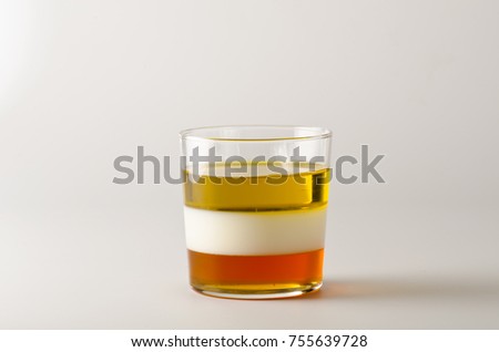 Physics. Density column. Laboratory glassware containing separed layers of vegetable oil, milk and honey.