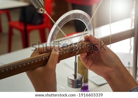 A physics experiment on equilibrium of three forces, angles measured by the protractor. Scientific practice concept. Scientific experiment.