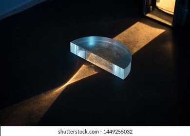 Physics experiment. Passing of a lightbeam through a positive lens, showing a convergent pattern. Light comes together in focal point.