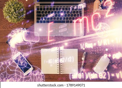 Physics and math theme hologram with formula drawings over computer on the desktop background. Top view. Multi exposure. Concept of education.