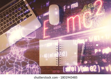 Physics and math theme hologram with formula drawings over computer on the desktop background. Top view. Multi exposure. Concept of education.