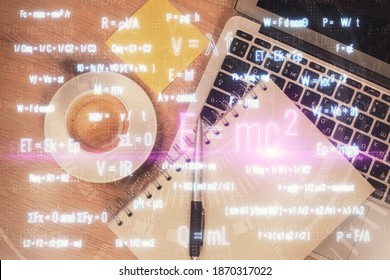 Physics and math theme hologram with formula drawings over computer on the desktop background. Top view. Multi exposure. Concept of education.