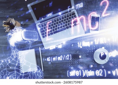 Physics and math theme hologram with formula drawings over computer on the desktop background. Top view. Multi exposure. Concept of education.