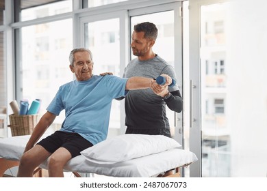 Physio, dumbbell and senior man with rehabilitation, arm muscle and check in clinic. Consultation, client and elderly care with physical therapy, wellness and injury support with chiropractor - Powered by Shutterstock