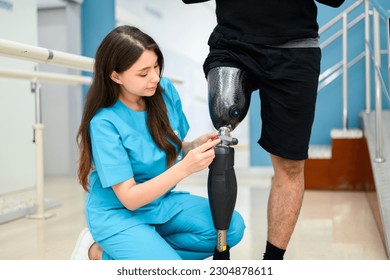 Physiotherapist adjusting prosthetic leg of patient in hospital - Powered by Shutterstock