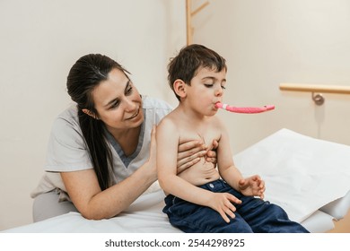 Physiotherapist assisting young boy with respiratory physiotherapy using pink device - Powered by Shutterstock