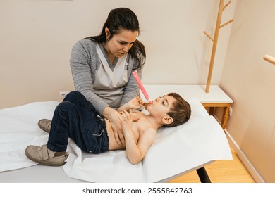 Physiotherapist assisting young boy with respiratory physiotherapy using pep mask - Powered by Shutterstock