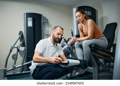 Physiotherapist And Athletic Woman Making Training Plans During Her Physical Therapy Treatment In Health Club. 