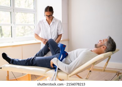 Physiotherapist Checking Man Patient Knee. Physiotherapy And Pain