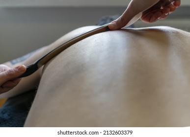  Physiotherapist Correcting Joint Pain Of Male Patient With IASTM Tool, Instrument Assisted Soft Tissue Mobilization Technique For Soft Tissue Treatment.