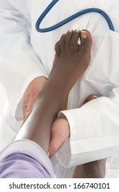physiotherapist doctor  treating foot tibia of an African American patient 