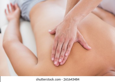 Physiotherapist doing back massage to her patient in medical office