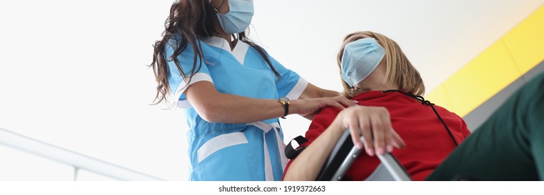 Physiotherapist Doing Back And Shoulder Massage To Disabled Young Woman In Wheelchair Wearing Protective Medical Masks. Rehabilitation Of People With Disabilities At Home In Context Of Covid19