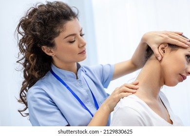 Physiotherapist doing healing treatment on womans neck,Chiropractic adjustment, pain relief concept.office syndrome - Powered by Shutterstock