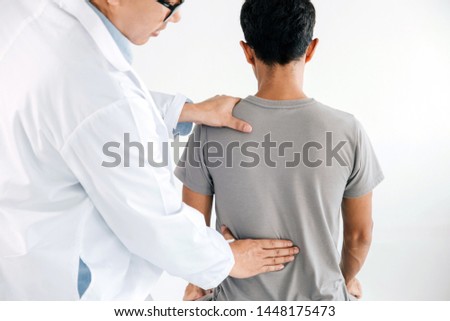 Physiotherapist doing healing treatment on man's back.Back pain patient, treatment, medical doctor, massage therapist.office syndrome
